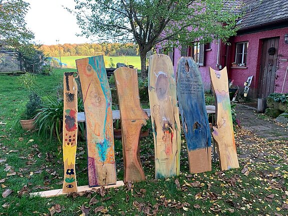 Bunt bemalte Holzbretter in einem Garten